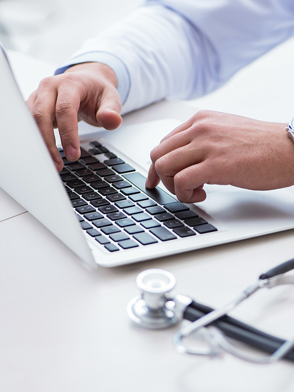 Doctor preparing for a virtual consultation on a laptop, representing the 50-minute Med Team Call.