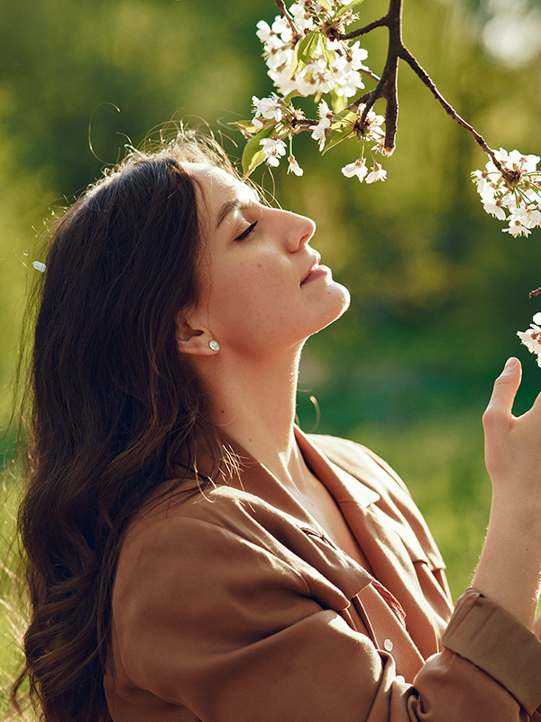 Symbolic photo for the Breathe Easy Kit: woman smelling a flower outdoors, representing seasonal allergy relief.